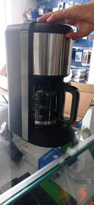a person is holding a coffee pot on top of a coffee maker at Janibichi Adventures hostel in Moshi