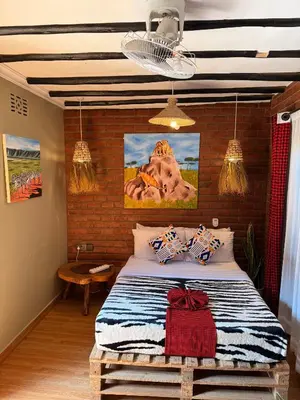 a bedroom with a bed with a painting on the wall at Swahili Villa in Arusha