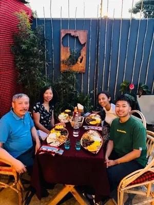 a group of people sitting around a table with food at Swahili Villa in Arusha