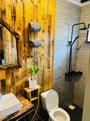 a bathroom with a white toilet and a sink at Swahili Villa in Arusha
