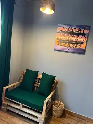 a chair with green cushions sitting in a room at Swahili Villa in Arusha