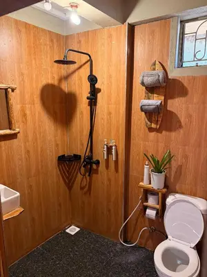a bathroom with a shower with a toilet in it at Swahili Villa in Arusha