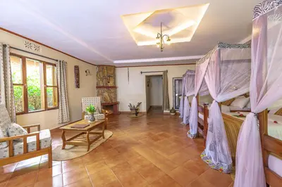 a room with two bunk beds and a table at KUDU LODGE & CAMPSITE in Karatu