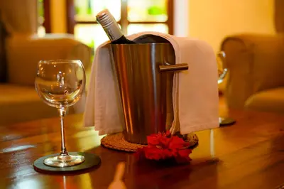 a bottle of wine in a container next to a glass at KUDU LODGE & CAMPSITE in Karatu