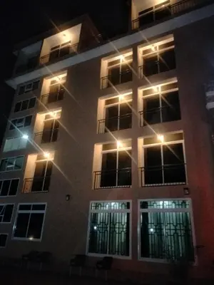 a tall building with lights on it at night at Aves Executive Hotel in Arusha