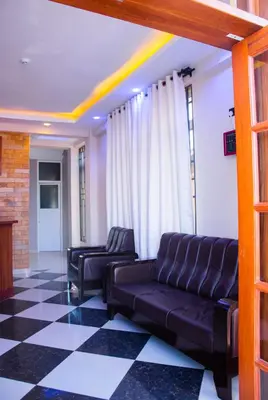 a living room with a couch and two chairs at Aves Executive Hotel in Arusha