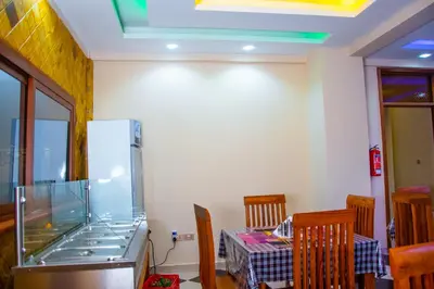 a kitchen with a aquarium and a table and chairs at Aves Executive Hotel in Arusha