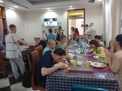 a group of people sitting at a table eating at Aves Executive Hotel in Arusha