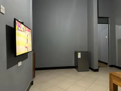 a room with a tv on the wall at Maro Homestay Sango in Old Moshi