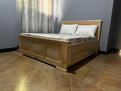 a wooden bed in a room with a window at Maro Homestay Sango in Old Moshi