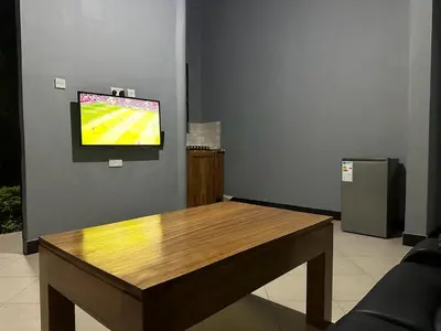 a table in a room with a television on a wall at Maro Homestay Sango in Old Moshi