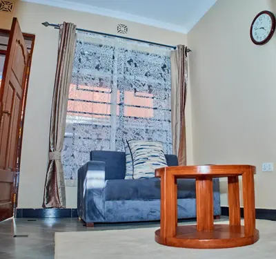 a living room with a blue couch and a table at Arusha Serene Apartments in Arusha