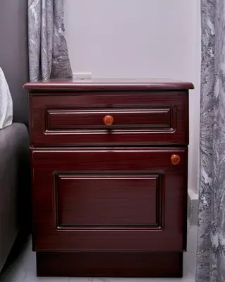 a wooden dresser with three drawers in a bedroom at Diamond Apartments in Arusha