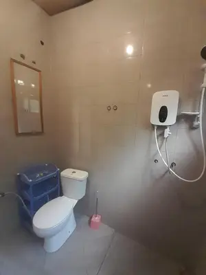 a bathroom with a white toilet and a mirror at Unique Heritage in Arusha