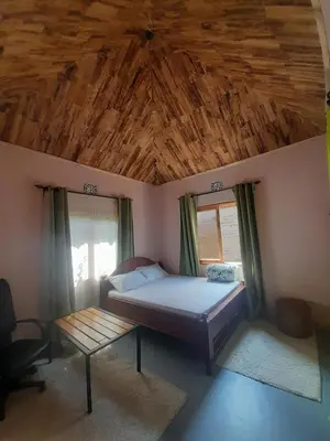 a bedroom with a bed and a wooden ceiling at Unique Heritage in Arusha