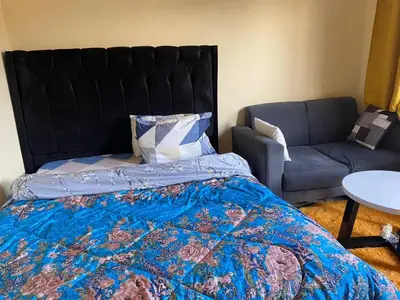 a bedroom with a bed and a couch at Maasaifari Osmlai in Arusha