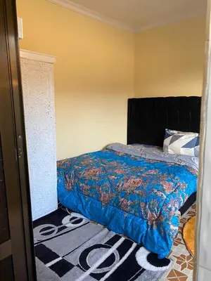 a bedroom with a bed with a blue comforter at Maasaifari Osmlai in Arusha