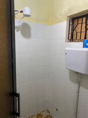 a bathroom with a white tiled shower with a window at Maasaifari Osmlai in Arusha