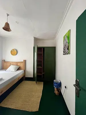 a bedroom with a bed and a zebra picture on the wall at Kobe Nature Homestay in Arusha
