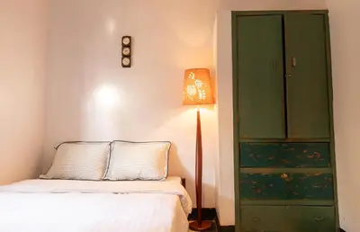 a bedroom with a bed and a green cabinet at Kobe Nature Homestay in Arusha