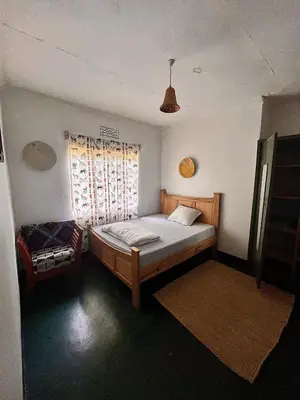 a bedroom with a bed and a window at Kobe Nature Homestay in Arusha
