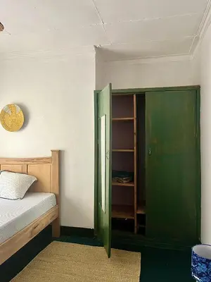 a bedroom with a green cabinet and a bed at Kobe Nature Homestay in Arusha