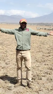 a man standing in the desert with his arms outstretched at Kobe Nature Homestay in Arusha