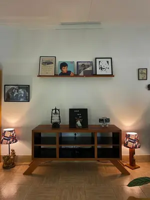 a living room with a table and pictures on the wall at Kobe Nature Homestay in Arusha