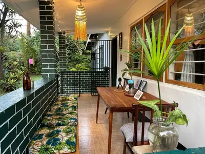 a porch with a wooden table and a plant at Kobe Nature Homestay in Arusha