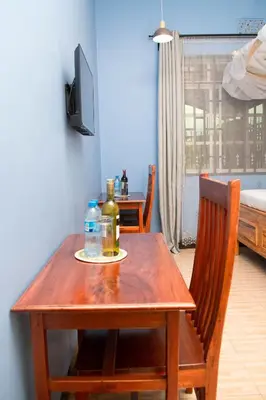 a wooden table with two bottles of alcohol on it at Kigongoni Gazella Hotel in Mto wa Mbu
