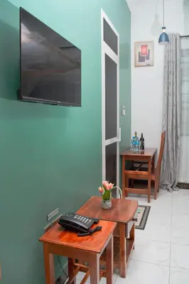 a room with a wooden table with a television on the wall at Kigongoni Gazella Hotel in Mto wa Mbu