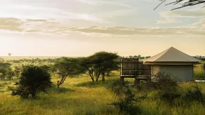 a building in the middle of a field with trees at Salinero Serengeti in Ututwa