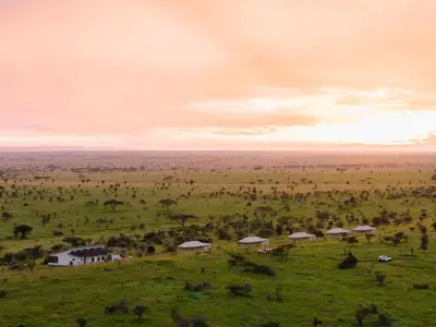 a field with a group of houses on a grassy field at Salinero Serengeti in Ututwa