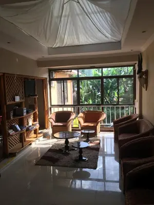 a living room with chairs and a table and a large window at maasaifari runako in Ilboru