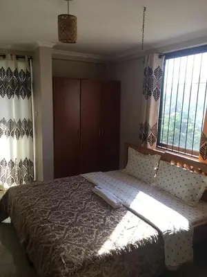 a bedroom with a large bed with a large window at maasaifari runako in Ilboru