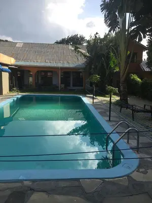 a blue swimming pool in front of a house at maasaifari runako in Ilboru