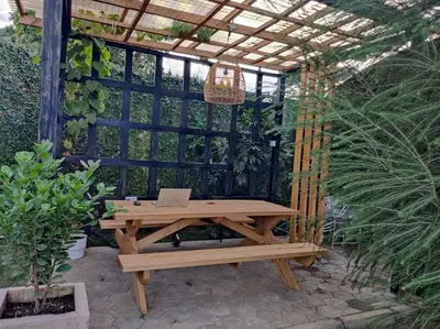 a wooden picnic table with a laptop on it at Luxury 2BR apartment in Usa River