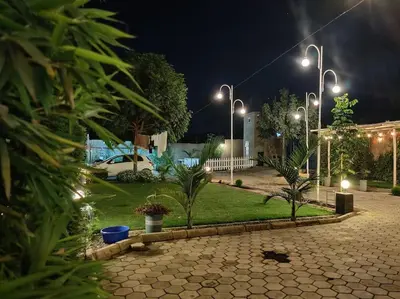 a park at night with street lights and plants at Luxury 2BR apartment in Usa River