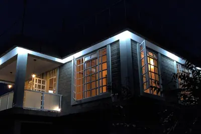 a house with lights on the side of it at night at Luxury 2BR apartment in Usa River