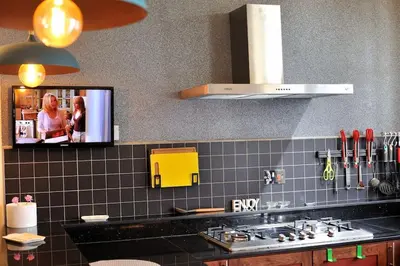 a kitchen with a tv on the wall at Luxury 2BR apartment in Usa River