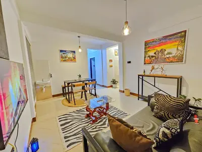 a living room with a couch and a table at Fly Africa Village in Arusha