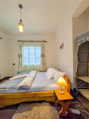 a bedroom with a bed and a lamp on a table at Fly Africa Village in Arusha