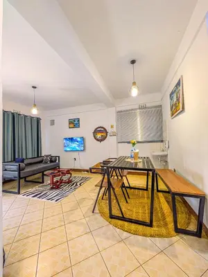 a living room with a table and a couch at Fly Africa Village in Arusha