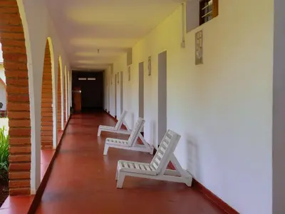 two white chairs sitting on a hallway with a hallway at Domus Aurea Safaris in Oldeani