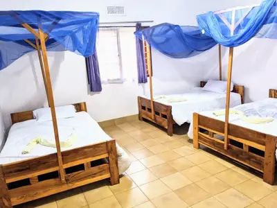 three beds in a room with blue umbrellas at Domus Aurea Safaris in Oldeani