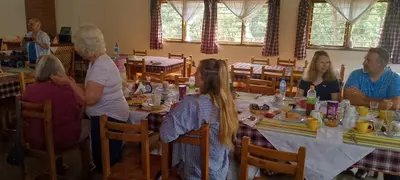 a group of people sitting at tables in a restaurant at Domus Aurea Safaris in Oldeani