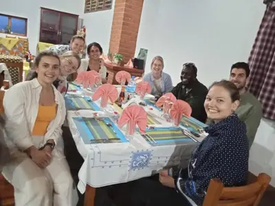 a group of people sitting around a table with a cake at Domus Aurea Safaris in Oldeani