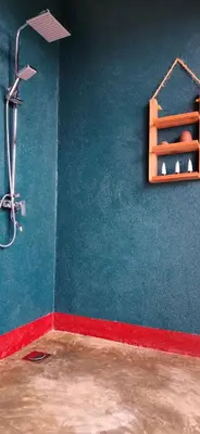 a bathroom with a shower and a blue wall at Mamadunia Safari Lodge in Karatu