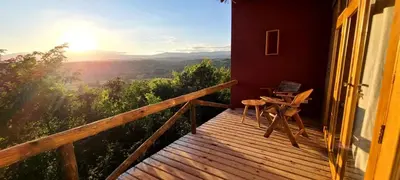 a wooden balcony with a table and chairs on it at Mamadunia Safari Lodge in Karatu