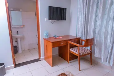 a desk and a chair in a bathroom with a sink at Selig Hotel in Moshi